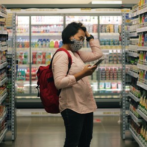 Une femme regarde les rayons d'aliments au supermarché