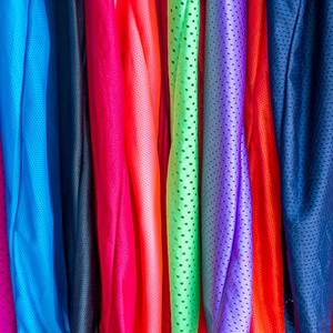 Des vêtements colorés en polyester rangés dans un magasin 