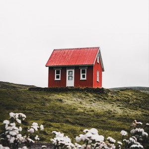 Une maison rouge en haut d'une colline