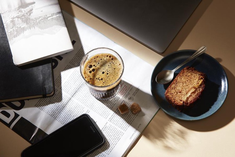 Un verre de chicorée Nourée avec une part de cake sur une table