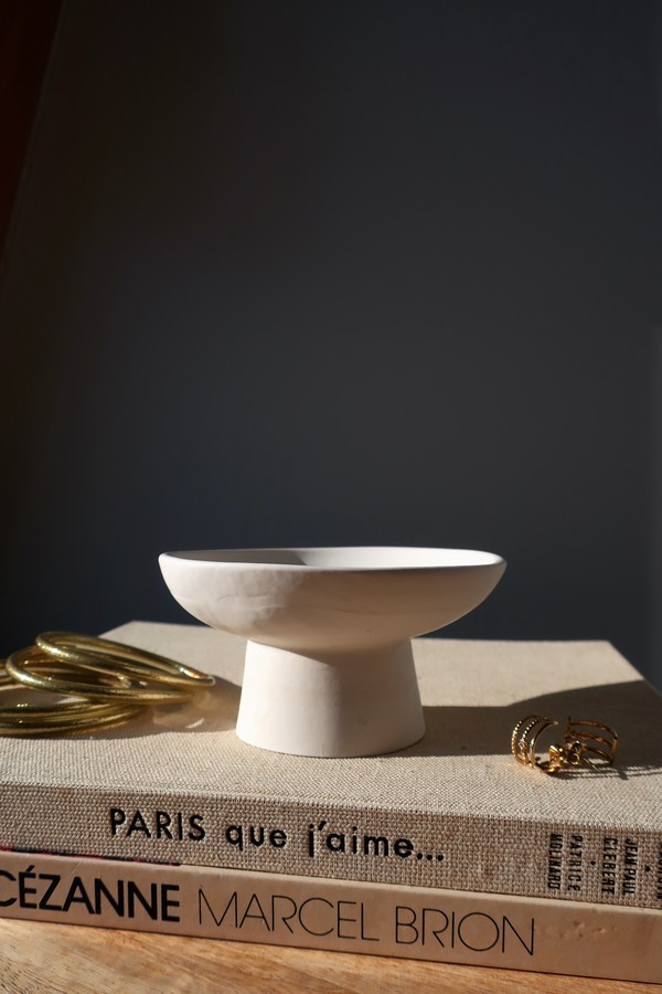 Assiette creuse / objet déco posé(e) sur des livres