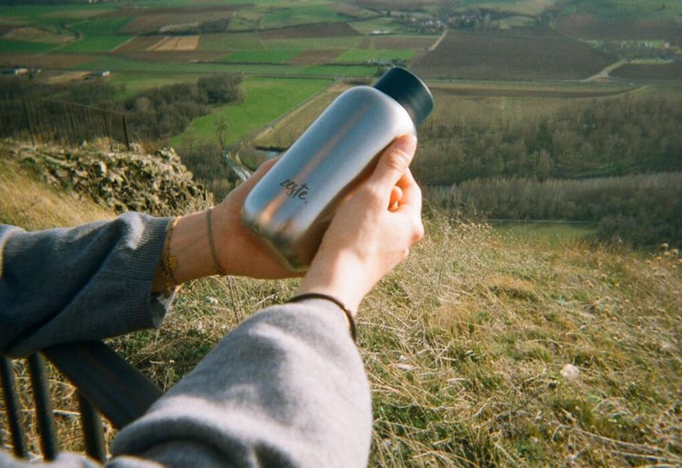 Des mains avec une bouteille Zeste