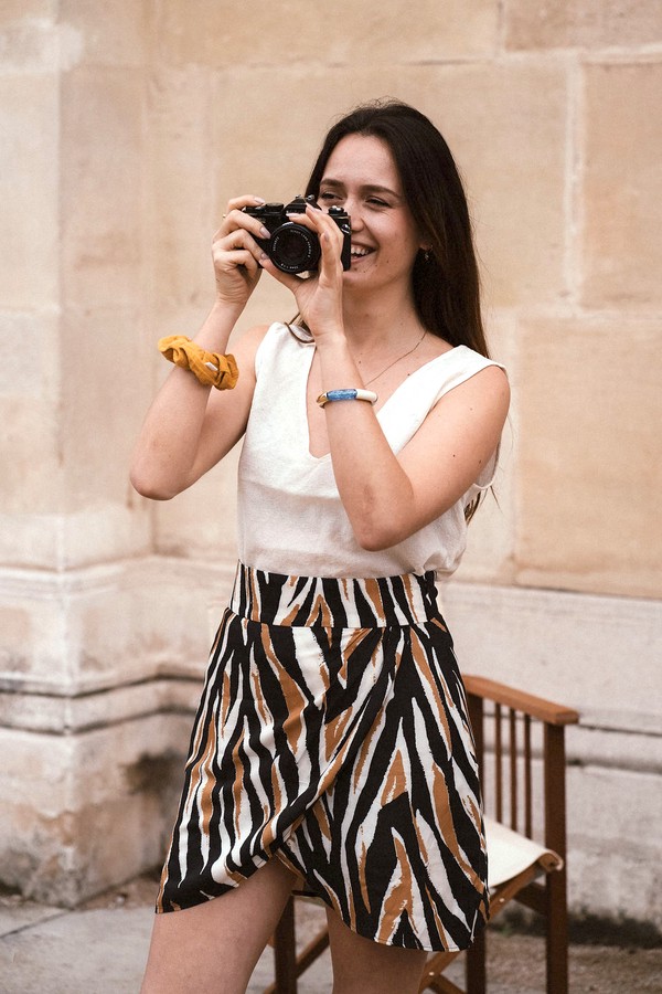 Une femme porte un top et une jupe-short imprimé zèbre