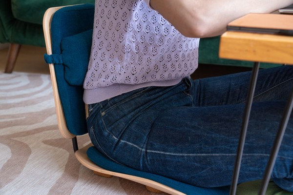 Quelqu'un qui travaille sur une table basse avec la chaise de sol Olidi